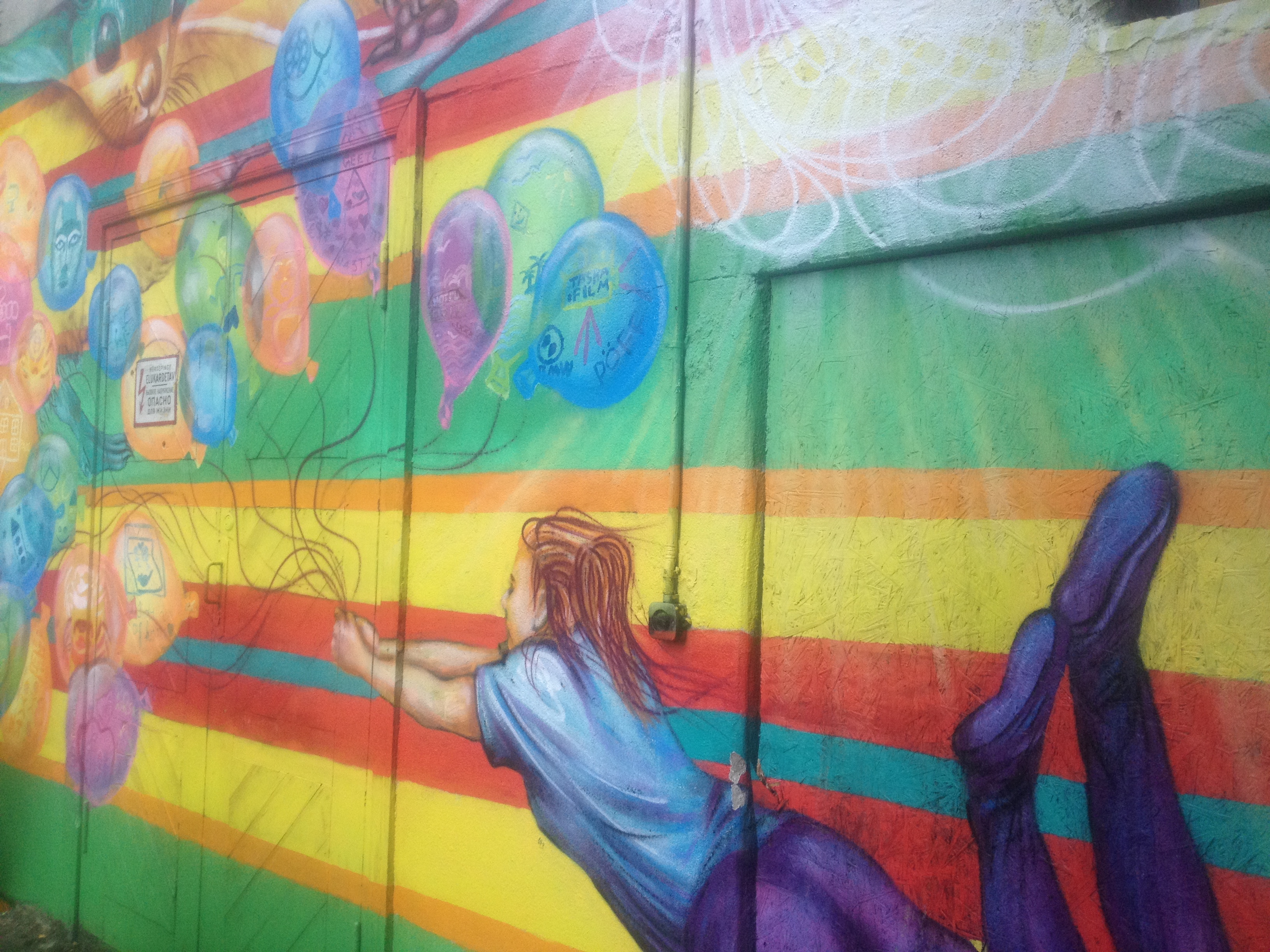 Värikäs maalaus, jossa on ilmapallojen varassa lentävä henkilö