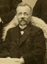 Kirjailija Juhana Kokko, silmälasipäinen ja parrakas mies, mustavalkoisessa, vanhassa valokuvassa.