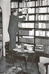Valokuva: V. A. Koskenniemi kirjahyllyllä vuonna 1948.