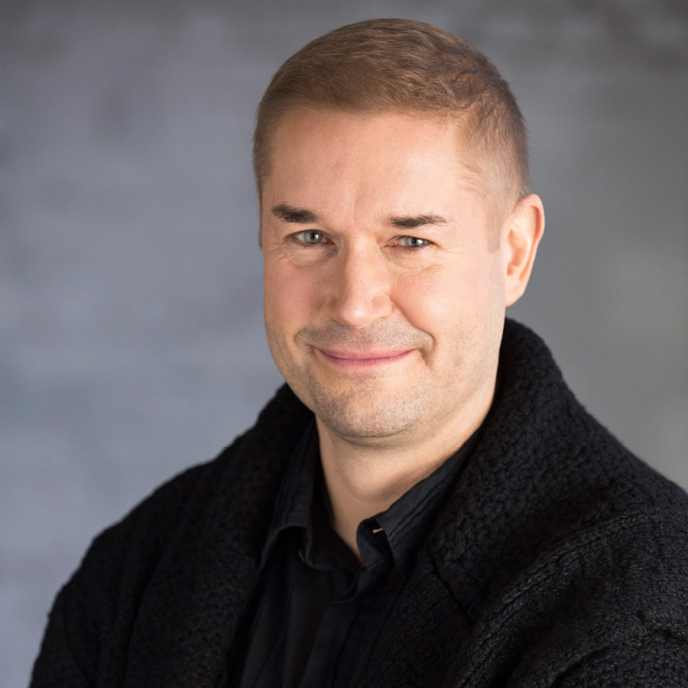  A man in a black shirt against a gray background