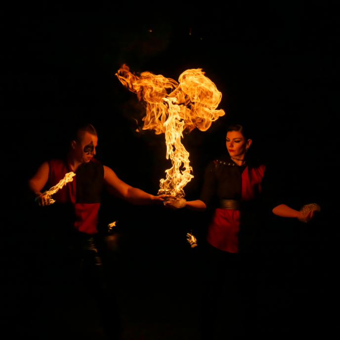 Two people standing with a large flame between them